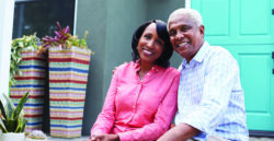 mature couple sitting on steps in front of home