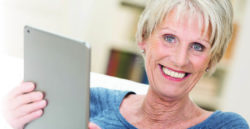 mature woman holding tablet and smiling