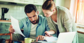 couple reviewing documents and using calculator