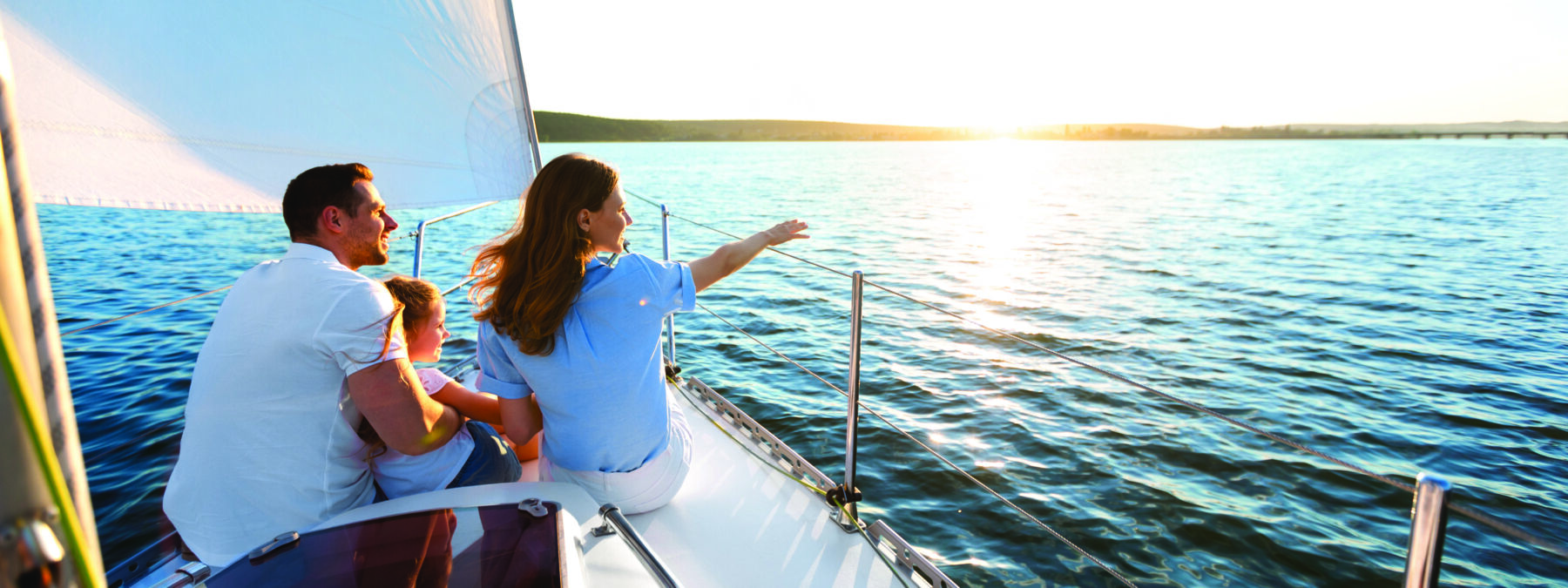 man woman and child sitting on front of sailboat